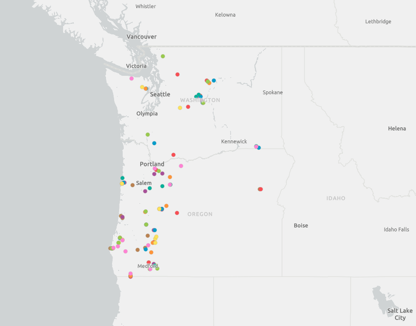 grayscale map of Washington and Oregon with many brightly colored dots indicating project locations